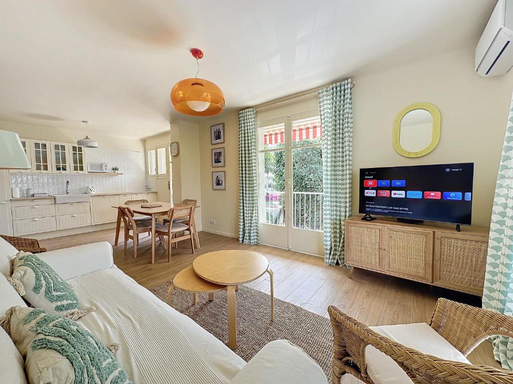 un salon avec un canapé et une télévision dans l'établissement 63m2 Grande Terrasse, Climatisation & Parking, 2BR, à Cannes