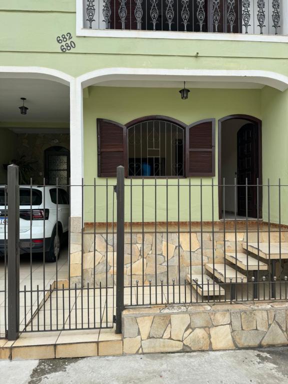a fence in front of a house with a car at Casa Rodrigues in São Lourenço