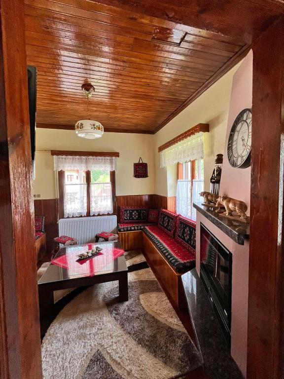 a living room with a fireplace and a clock on the wall at Rustic House in Miléa