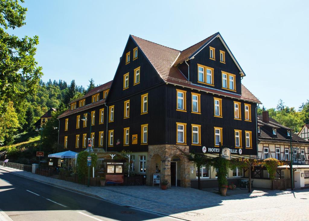 un gran edificio negro al lado de una calle en GreenLine Ferienhotel Forelle en Thale