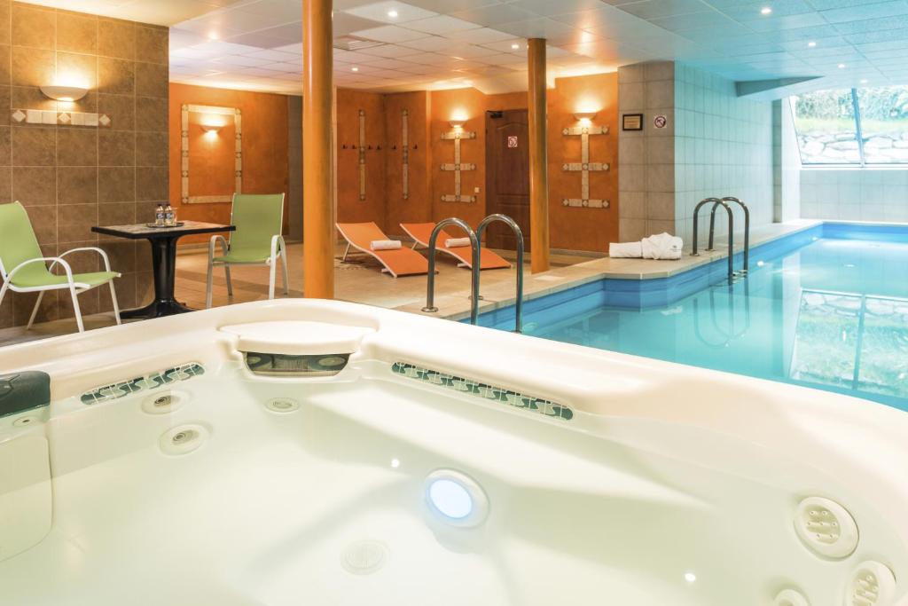 a bath tub in a bathroom with a pool at Hotel Vivaldi in Karpacz