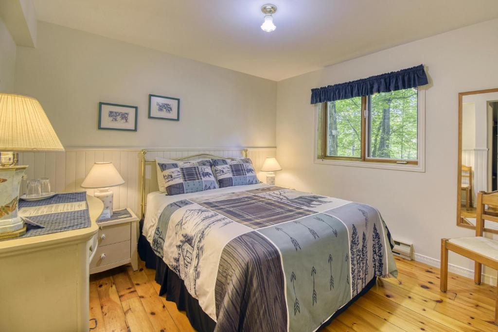 a bedroom with a bed and a desk and a window at Auberge Le Lupin-Self Check-in in Mont-Tremblant