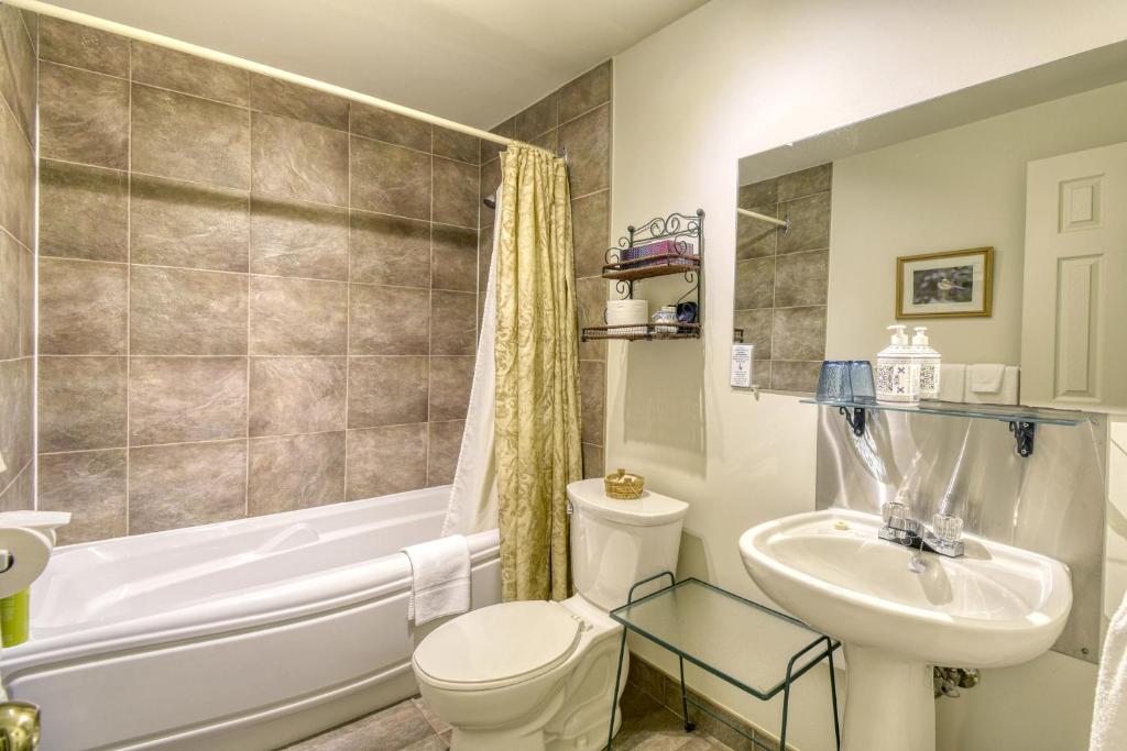 a bathroom with a toilet and a sink and a tub at Auberge Le Lupin-Self Check-in in Mont-Tremblant
