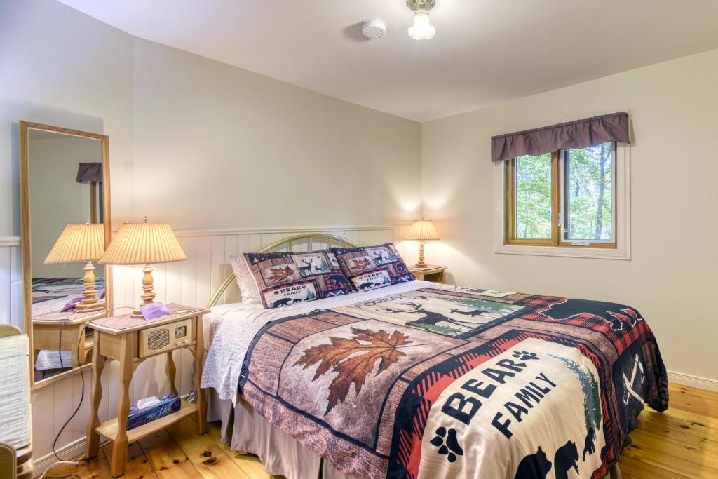 a bedroom with a bed and a table with a mirror at Auberge Le Lupin-Self Check-in in Mont-Tremblant