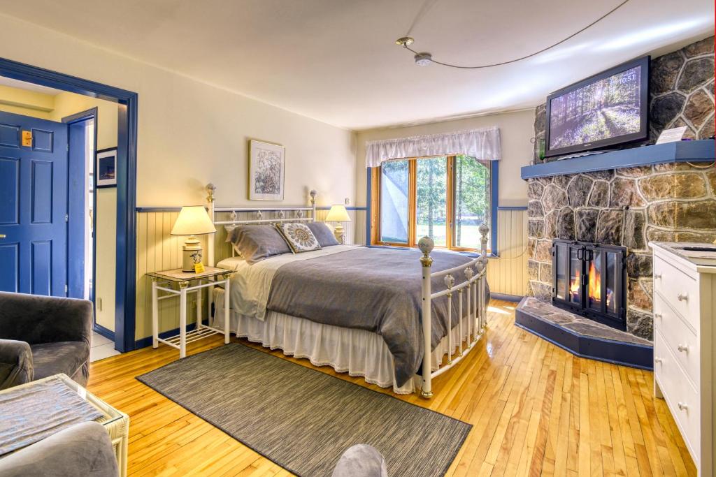 a bedroom with a bed and a fireplace at Auberge Le Lupin-Self Check-in in Mont-Tremblant