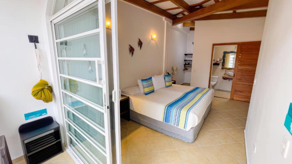 a bedroom with a bed and a glass door at Hotel Galapagos Suites B&B in Puerto Ayora
