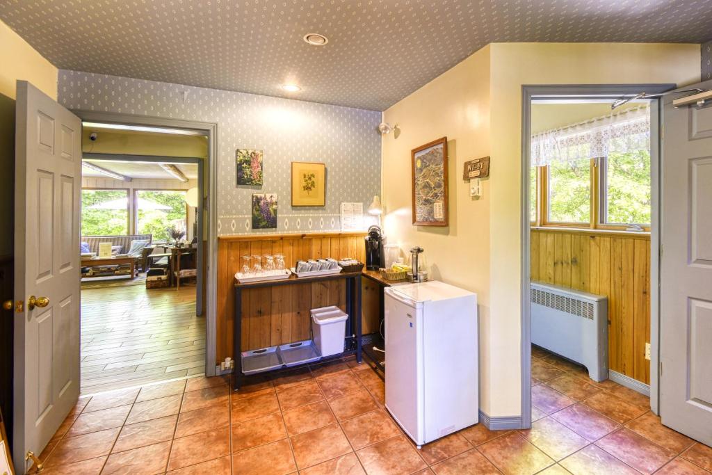 a kitchen with a white refrigerator in a room at Auberge Le Lupin-Self Check-in in Mont-Tremblant