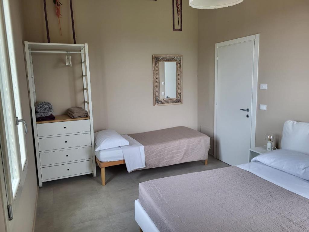 a small bedroom with two beds and a mirror at Podere Mantignano 2 in Faenza