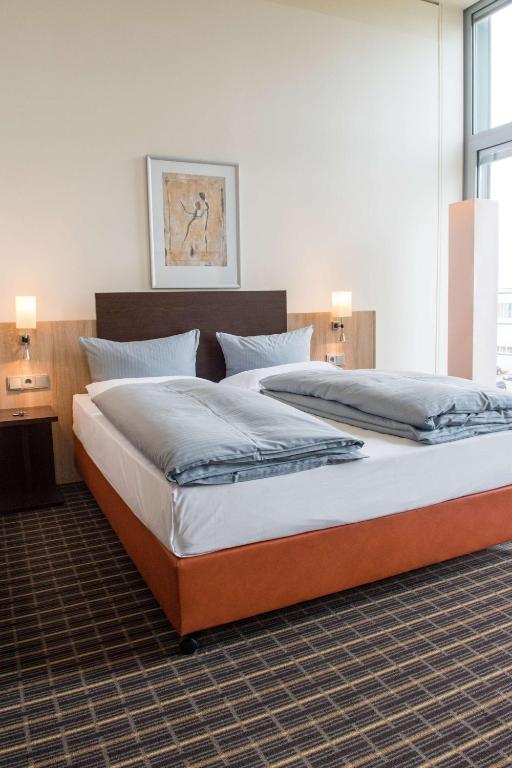 Postel nebo postele na pokoji v ubytování Livenwork Hotel & CoWorking GVZ Ingolstadt