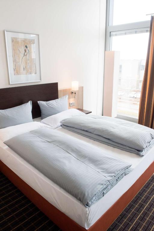 Postel nebo postele na pokoji v ubytování Livenwork Hotel & CoWorking GVZ Ingolstadt