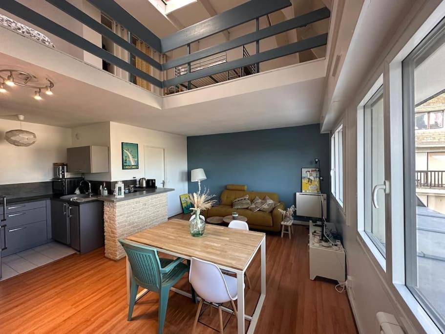 une cuisine et un salon avec une table et un canapé dans l'établissement Appartement Trouville Duplex piscine chauffée, à Trouville-sur-Mer