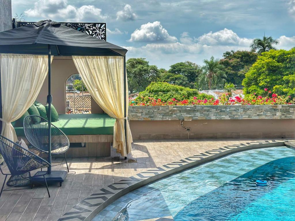 a patio with an umbrella and a pool at Hotel Osvé Boutique Cali in Cali