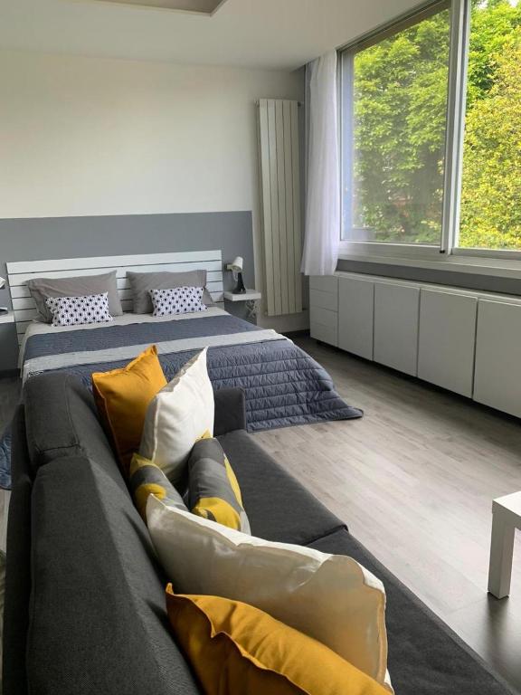 a bedroom with two beds and a couch at Son Sogni Holiday House in Leggiuno