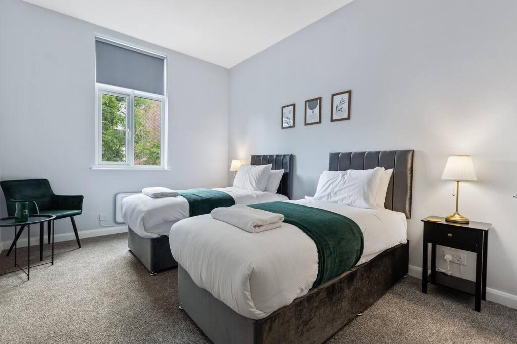 een slaapkamer met 2 bedden en een stoel bij Modern Apartment King with Free Parking Suite 6 in Nottingham
