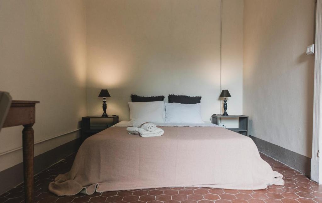 a bedroom with a large white bed with two lamps at Una Casa Bottega in Barco