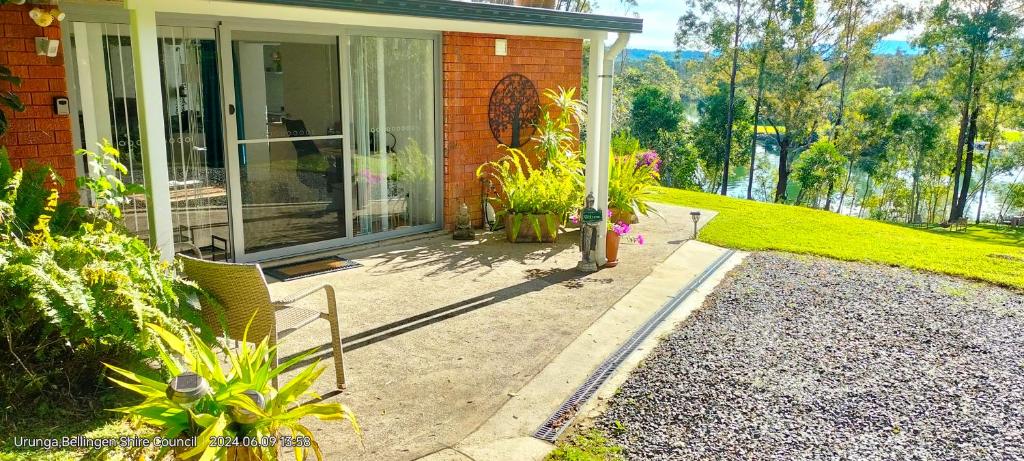 a home with a patio with plants on it at The Glade, peace among the trees on the river in Urunga