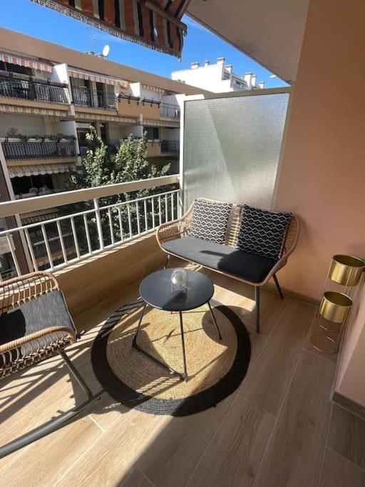 d'un balcon avec un banc, une table et une chaise. dans l'établissement Appartement 4 pièces de luxe à Juan-les-Pins, à Antibes