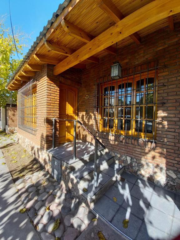 a brick house with a wooden roof and a porch at Casa Céntrica Excelente Ubicación in San Rafael