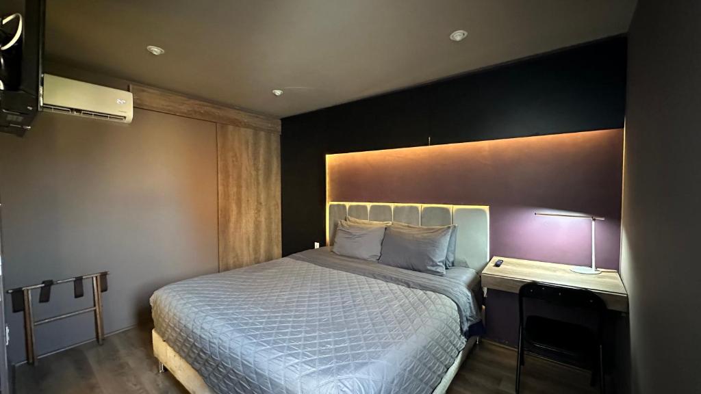 Un dormitorio con una cama grande y una lámpara sobre una mesa. en Maison Pascual - Centro Histórico, en San Luis Potosí