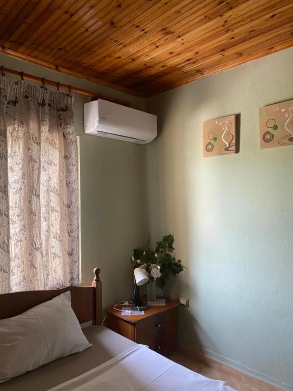 a bedroom with a bed and a window with a lamp at Marko's House in Gjirokastër
