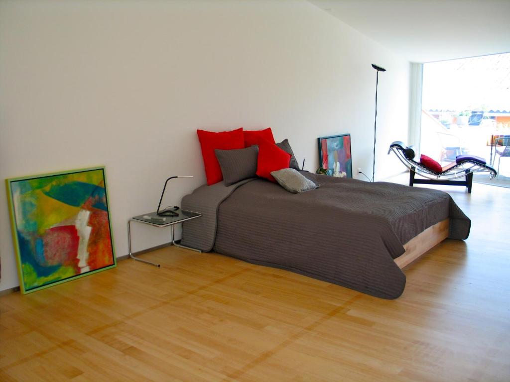 a bedroom with a large bed with red pillows at Artist's Loft zur Maloya in Ormalingen