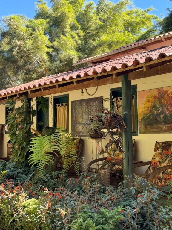 a porch of a house with plants on it at Pousada Passaredo in Brumadinho