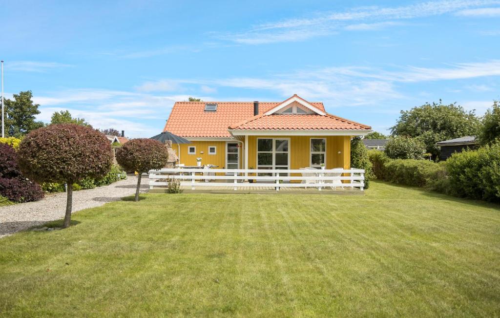 a yellow house with a white fence in a yard at Gorgeous Home In Otterup With Sauna in Otterup