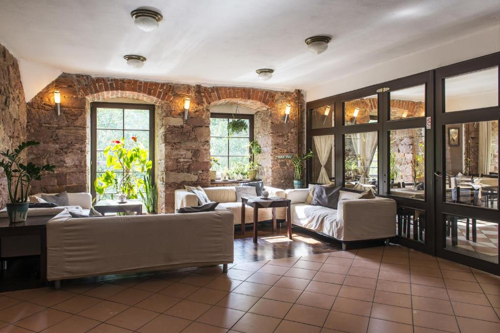 a living room with white couches and a brick wall at Centrum Turystyki Niekonwencjonalnej in Srebrna Góra