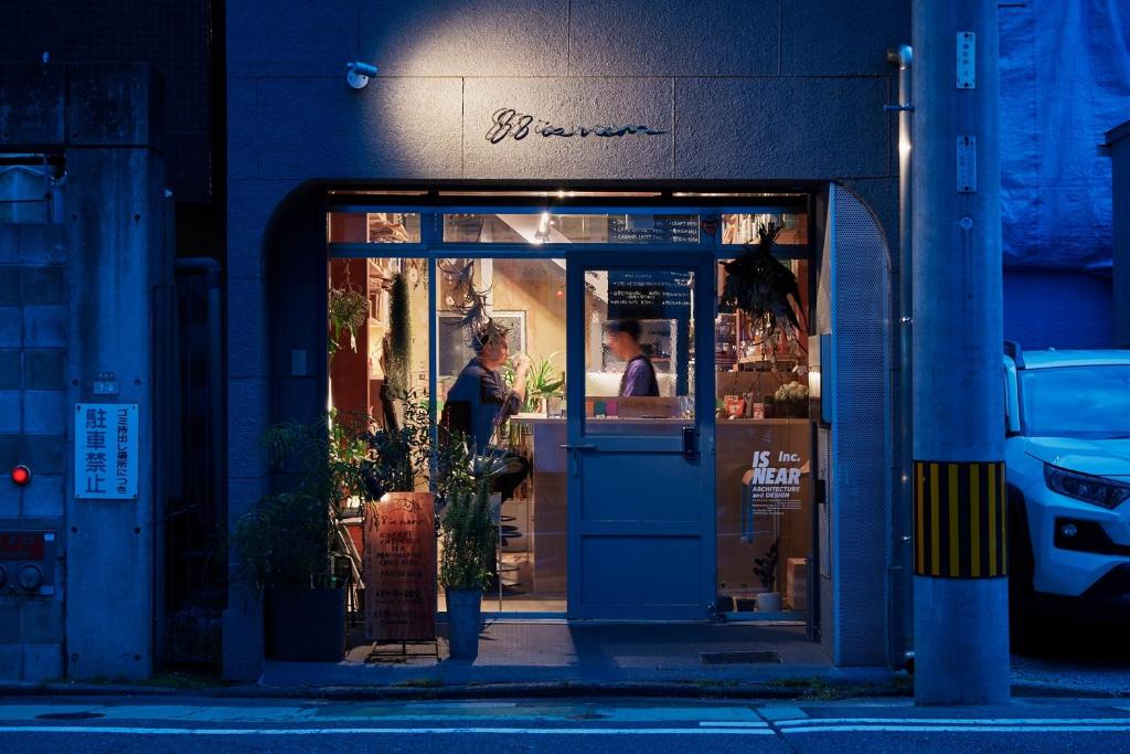 福岡市にある88 is near STAY Fukuoka Hakataの店の出入り口に立つ女