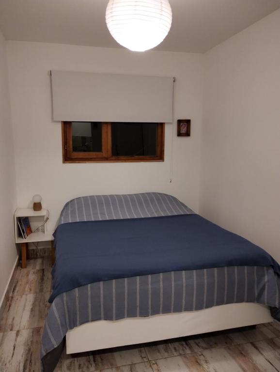 1 dormitorio con cama y ventana en Casa cronopio en Ushuaia