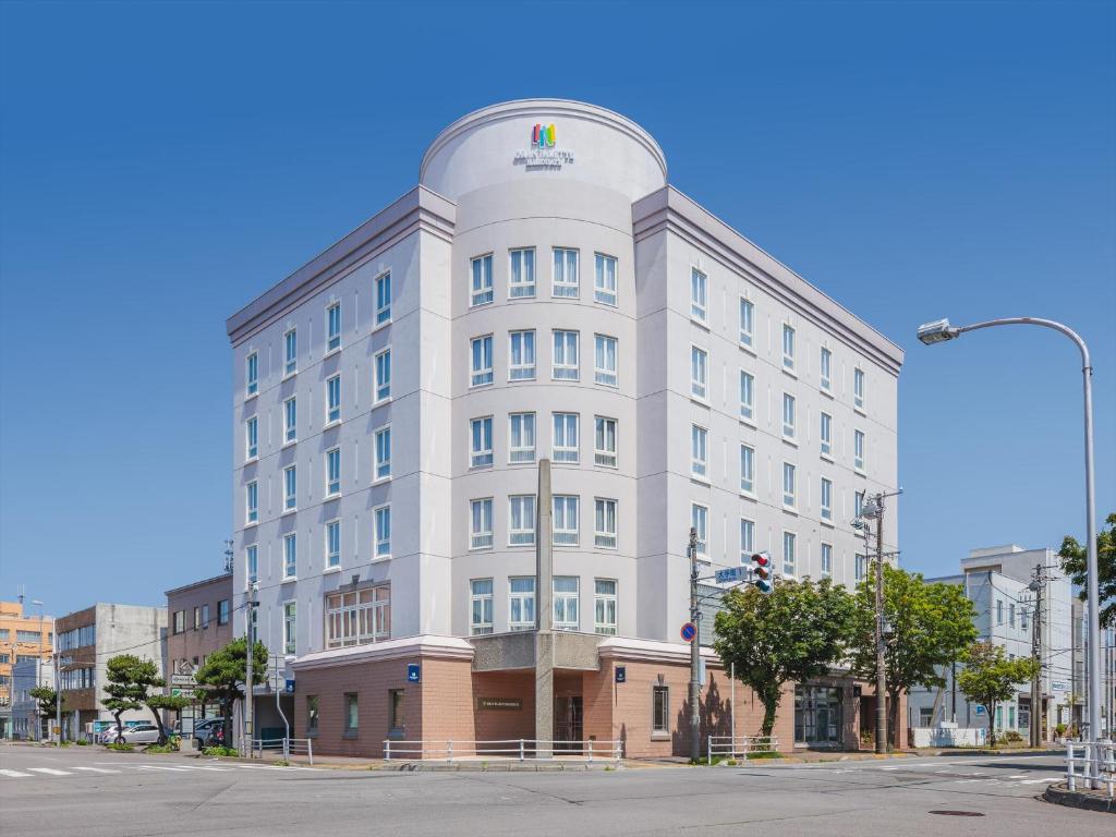 a white building with a round top on a street at Gran Palette Hakodate in Hakodate