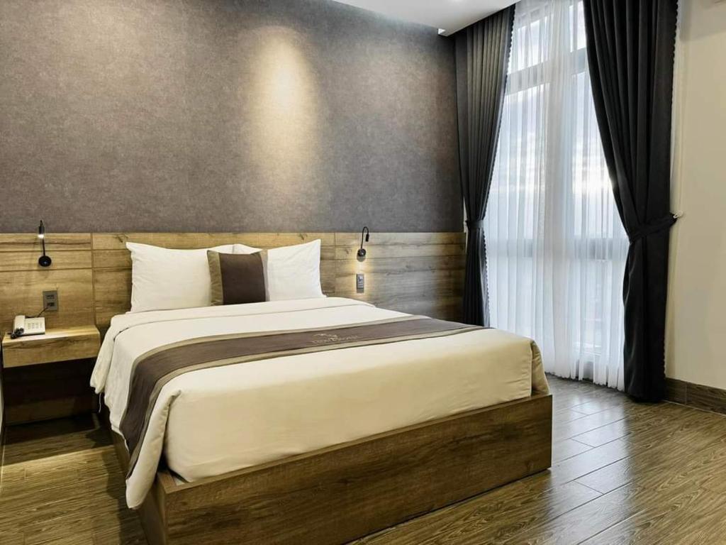 Un dormitorio con una cama grande y una ventana en LION 6 HOTEL, en Can Tho