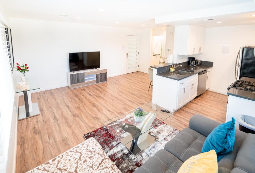 a living room with a couch and a kitchen at Sleek 1-Bedroom Apartment with AC & gated Parking space in Los Angeles