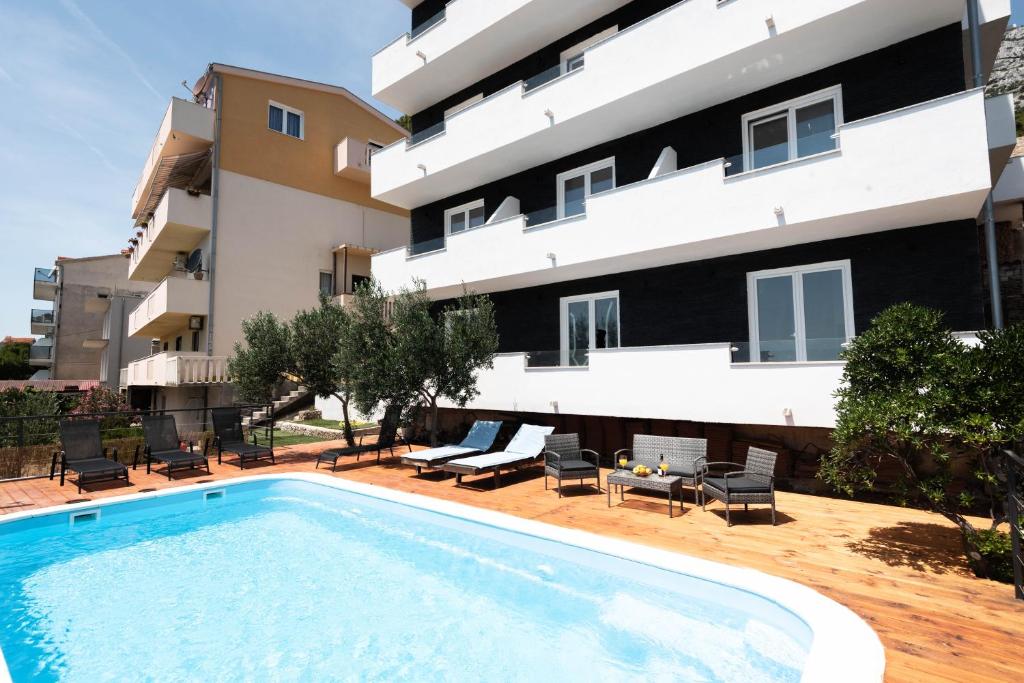 an apartment with a swimming pool in front of a building at Angeli Del Mare in Marusici 