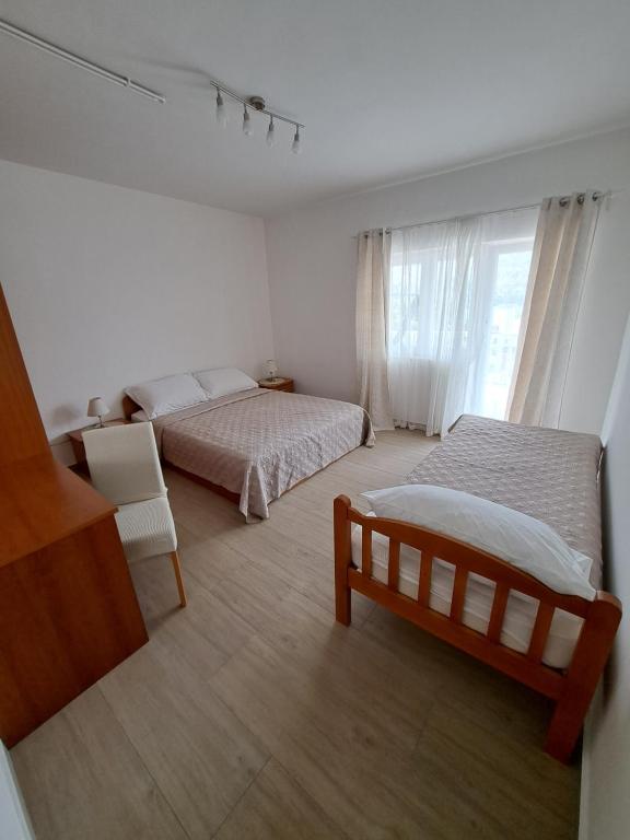 a bedroom with two beds and a window at Apartman G&L in Grebaštica