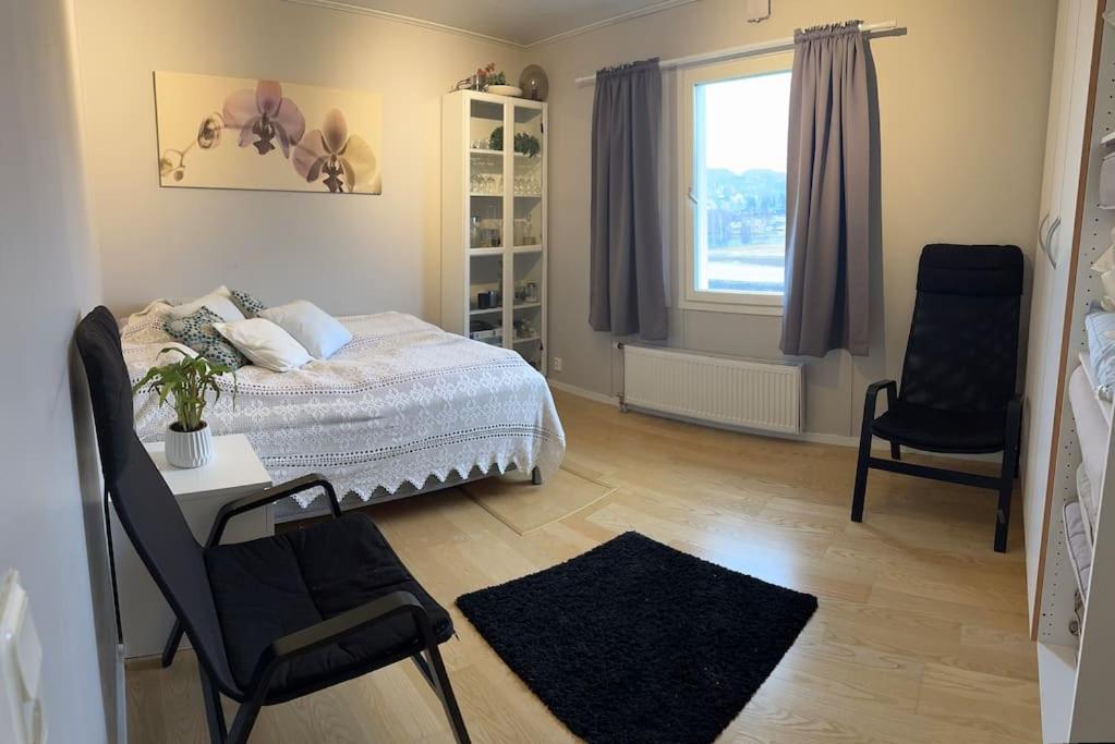 a bedroom with a bed and two chairs and a window at Enebolig nær Telemarkskanalen med nydelig utsikt in Norem