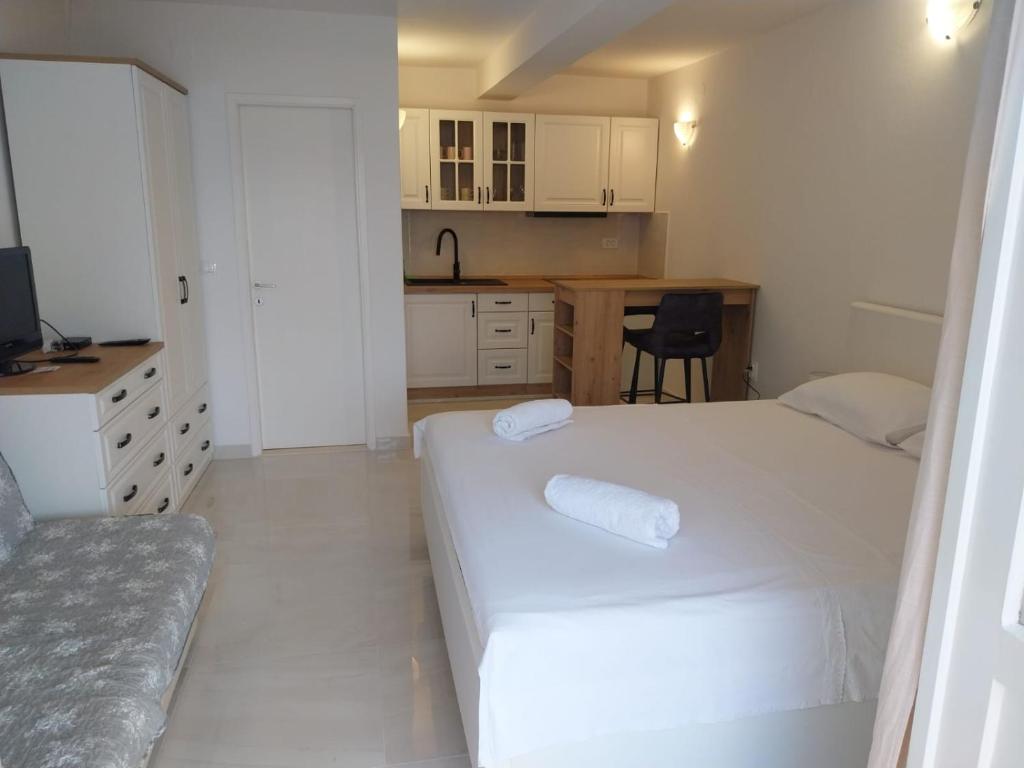 a small room with a bed and a kitchen at Apartments Lumbarda in Lumbarda