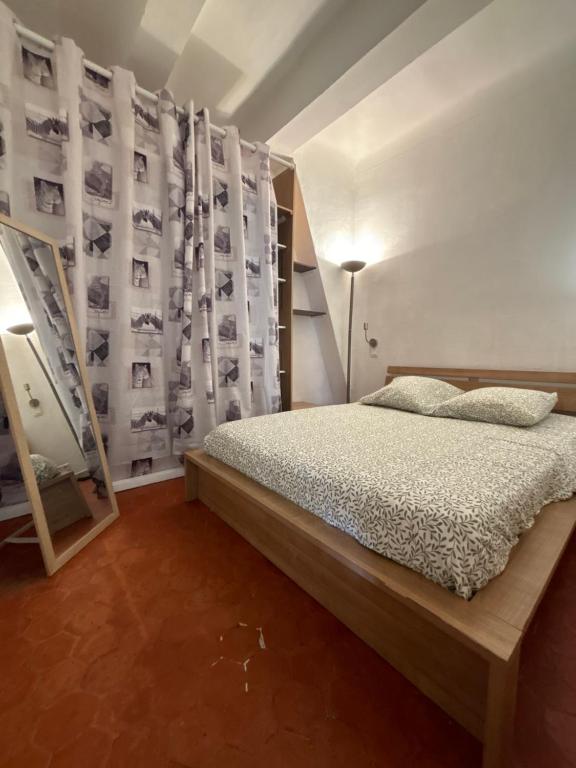 - une chambre avec un lit et un mur avec des photographies dans l'établissement Le Matheron, à Aix-en-Provence