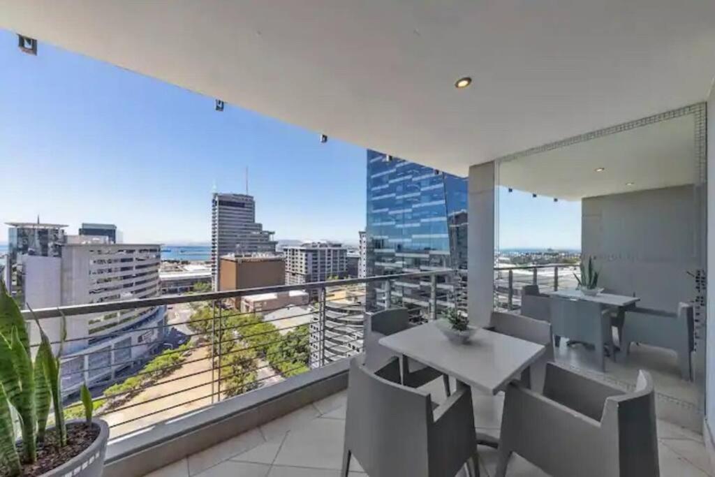 a balcony with a table and chairs and a view of the city at The Icon Capetown in Cape Town