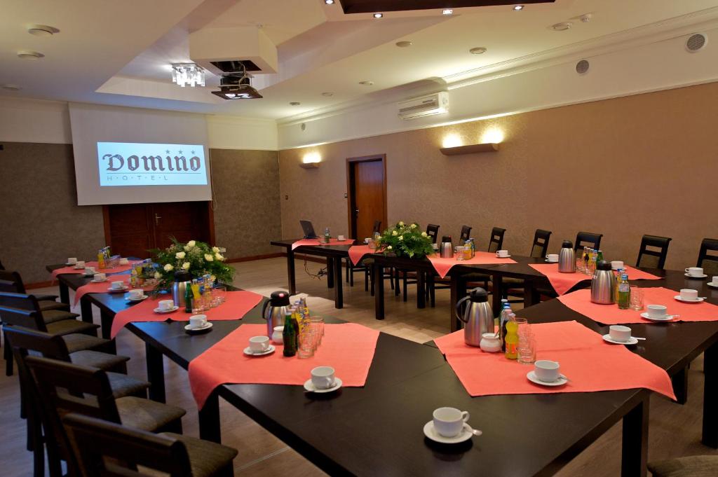 una sala de conferencias con mesas y sillas y una presentación en Hotel Domino en Głubczyce