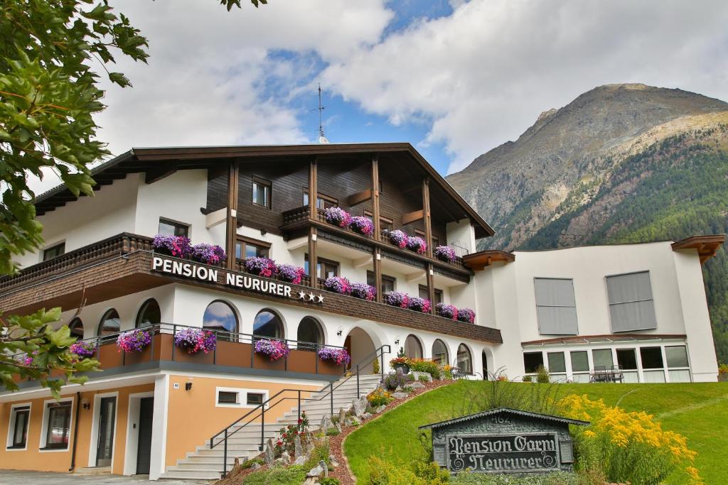 ein Hotel in den Bergen mit Blumen auf dem Balkon in der Unterkunft Pension Neururer in Sölden