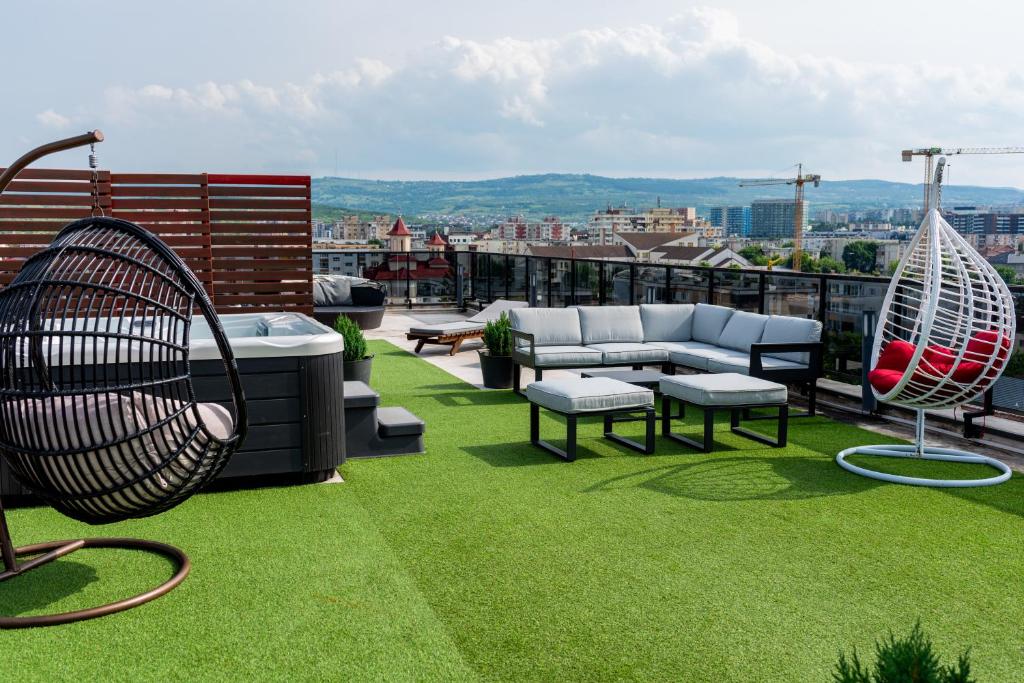 een terras met een hangmat en meubilair op een dakterras bij Thome Vlaicu170 Jacuzzi in Cluj-Napoca