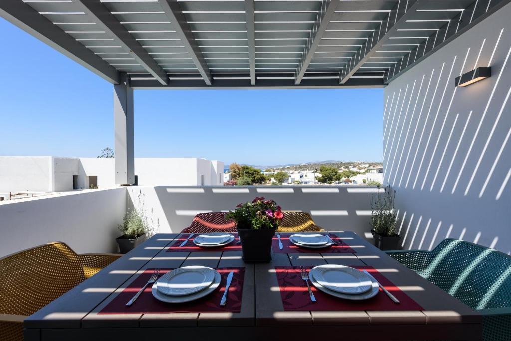 a table with plates and dishes on a balcony at OneAlyki in Aliki