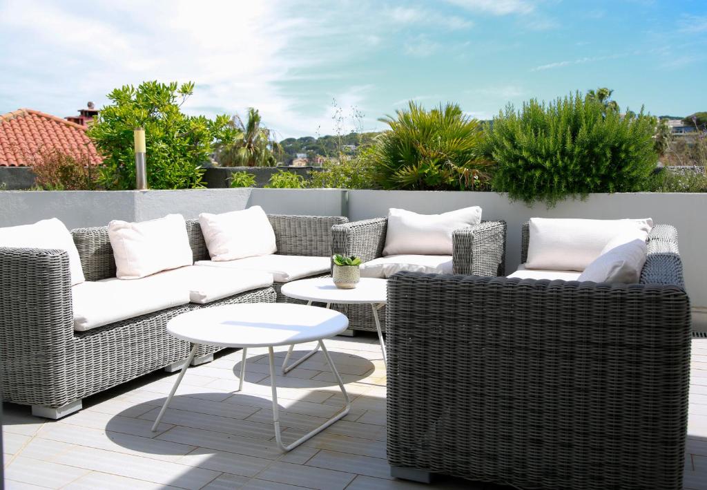 d'une terrasse avec des meubles en osier et une table. dans l'établissement Duplex en Rooftop vue mer à la Salis, à Antibes
