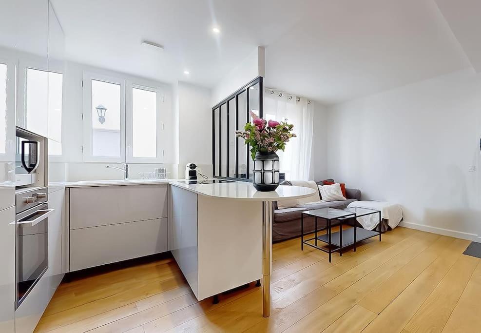 une cuisine avec une table avec un vase de fleurs dessus dans l'établissement Charmant Appartement 1 Chambre - Nation, à Paris