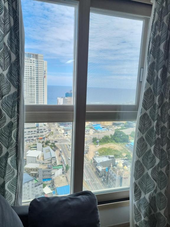 ein Blick auf eine Stadt aus einem Hotelzimmerfenster in der Unterkunft Sokcho Koaroo Arista in Sokcho