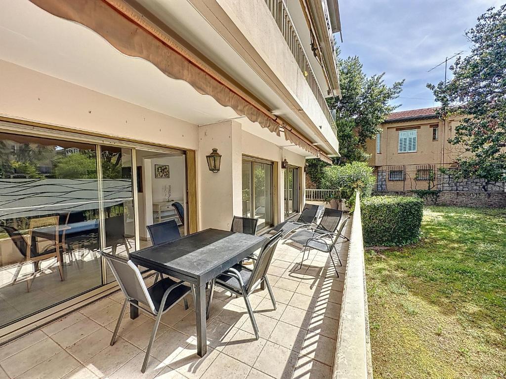 d'une terrasse avec une table et des chaises noires. dans l'établissement 130m2 Terrasses, Jardin, 4chambres, Climatisation, à Cannes