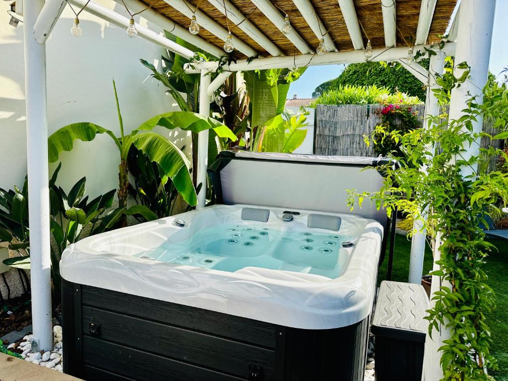 un bain à remous assis sous une pergola dans l'établissement Séjour Détente! Jacuzzi + Jardin privés, à Saint-Raphaël