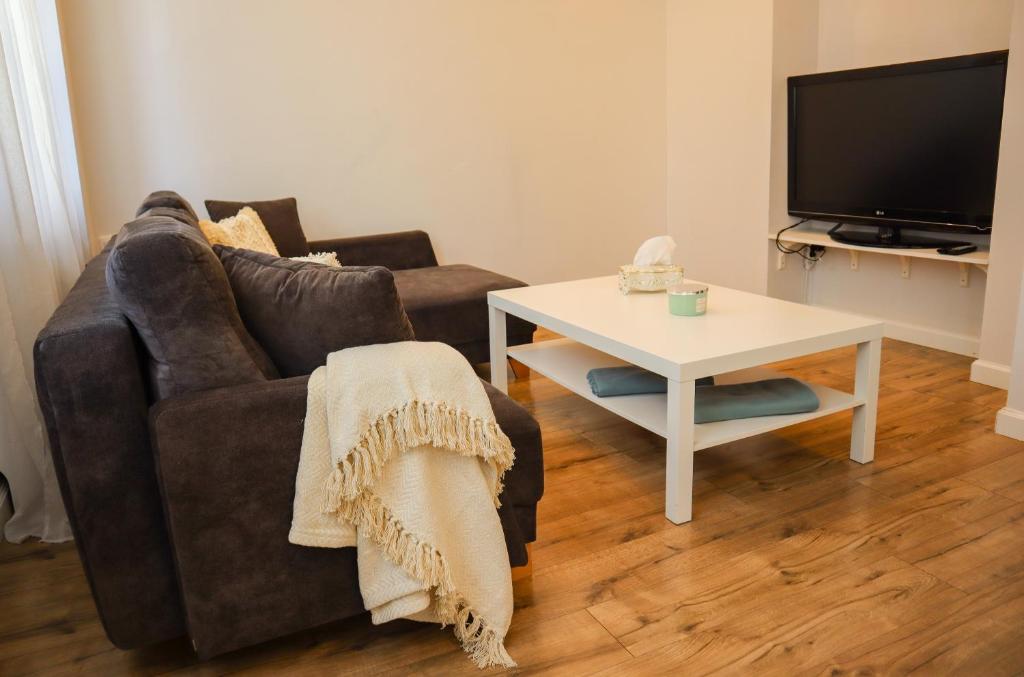 una sala de estar con un sofá y una mesa en Strzelecka Old Town Apartament, en Gdansk