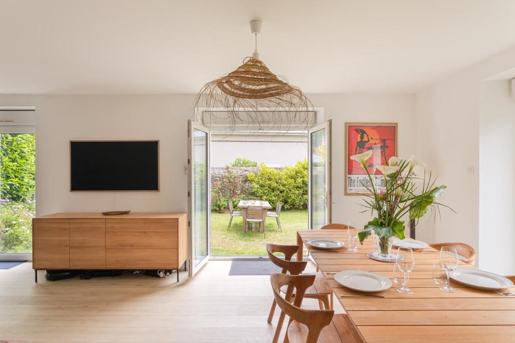 ein Esszimmer mit Tisch und Fernseher in der Unterkunft Bagatelle - Appt à 300 m de la plage in Dinard
